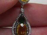 Quelqu'un tient une paire de boucles d'oreilles en diamants jaunes et blancs.