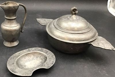a silver teapot and a silver plate on a table