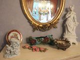 a table with a mirror and a statue on it
