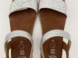 a pair of white sandals on a white surface with a white background