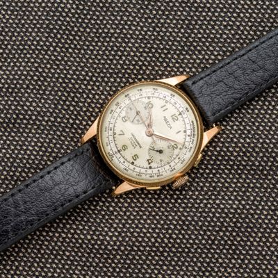 un gros plan d'une montre avec un bracelet noir posée sur une surface noire