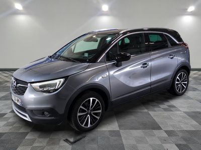 une voiture grise est garée sur le sol à carreaux d'un garage