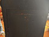 a black cabinet with a hat on top of it