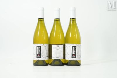 trois bouteilles de vin blanc posées les unes à côté des autres sur une table