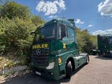 two green trucks parked next to each other in a parking lot