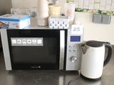 a microwave that is sitting on a counter with a tea kettle