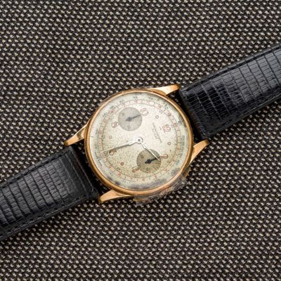 un gros plan d'une montre avec un bracelet noir posée sur une table