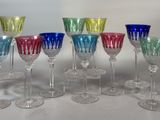 douze verres à vin colorés alignés en rang sur une table