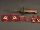 several military badges and a wooden knife on a table