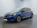 Une voiture bleue est garée dans une pièce aux murs blancs.