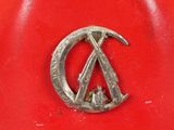 a close up of a metal emblem on a red object