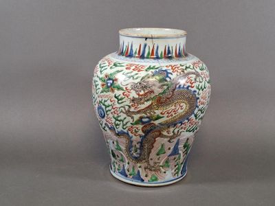 a vase with a dragon on it sitting on a table