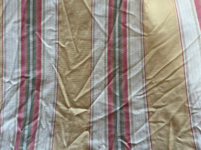 a close up of a bed with a striped comforter on it