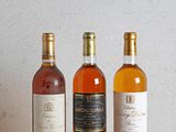three bottles of wine sitting on a table next to each other