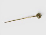 une barrette en forme de fleur en or et émeraude