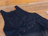 black dress with holes cut out of it on a wooden floor