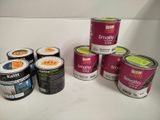 plusieurs pots de peinture posés sur un plan de travail blanc