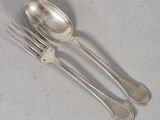 two forks and a spoon sitting on a table