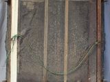 an old wooden frame with a window and a green rope