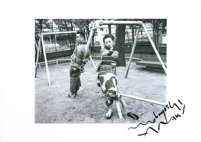 a black and white photo of a boy and a dog on a swing