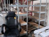 une chaise de bureau noire posée devant une rangée d'étagères