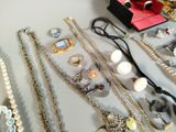 many necklaces and bracelets laid out on a table