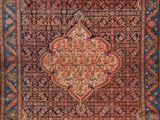 an antique persian rug with a medallion design on a blue ground