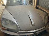 une voiture garée dans un garage, avec de la terre par terre