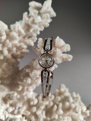 une bague en argent sertie d'un diamant, posée sur un corail