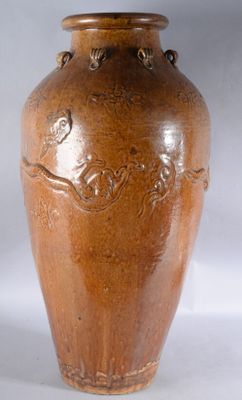un vase brun posé sur une surface blanche