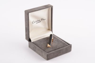 une petite boîte contenant un stylo, posée sur une surface blanche