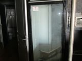 a refrigerator with a glass door in a dark room