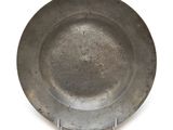 une assiette en argent avec un manche en métal sur un fond blanc