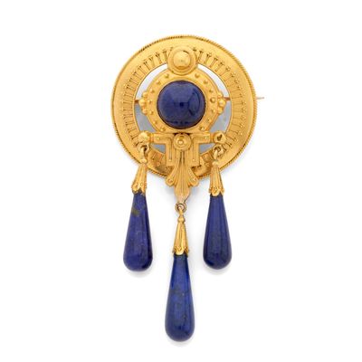 un gros plan sur une broche en or ornée de gouttes bleues