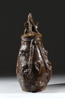 une image représentant un vase marron surmonté d'un oiseau