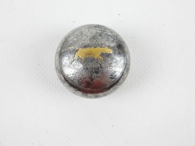 a close up of a metal button with a dog on it