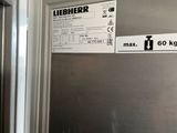 a stainless steel refrigerator with a sign on the door