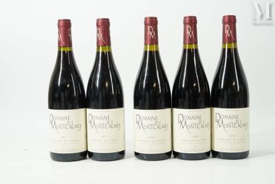 quatre bouteilles de vin sont alignées sur une surface blanche