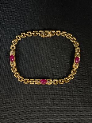un bracelet en or orné de pierres roses sur fond noir