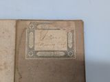 an old book with writing on it sitting on a table