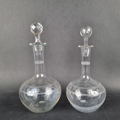 une paire de carafes en verre transparent posées sur un support noir