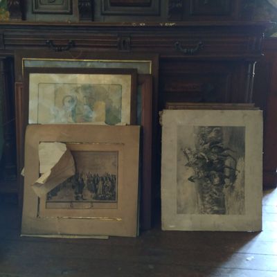 deux photos encadrées posées par terre à côté d'un piano