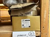 une pancarte posée sur une étagère dans une pièce où se trouvent des cartons et d'autres objets