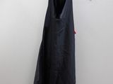 black dress hanging on a hanger against a white wall