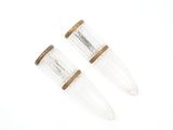 une paire de bouchons en verre transparent et en bois sur fond blanc