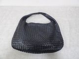 woven black leather purse on a white background