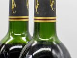 two bottles of wine sitting next to each other on a table