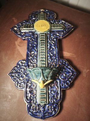 a blue and yellow wall hanging with a cross on it