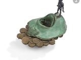 une statue représentant un homme debout au sommet d'un tas de pièces de monnaie