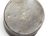 an old metal container with a number on it sitting on a white surface